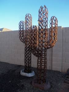 a large metal cactus sculpture sitting next to a wall