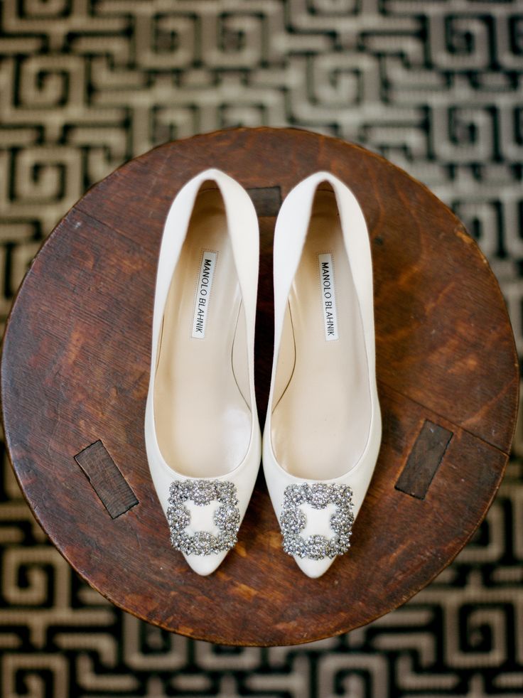 a pair of white shoes sitting on top of a wooden table