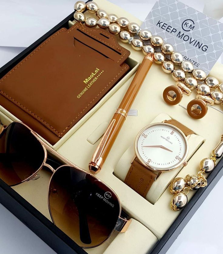 a watch, sunglasses, pen and wallet are in a box with some other items