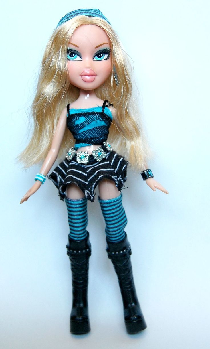 a close up of a doll with long blonde hair and blue eyes wearing black boots