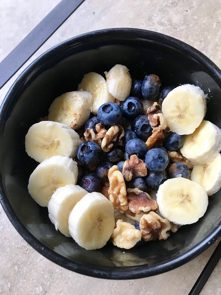 a bowl filled with blueberries, bananas and walnuts