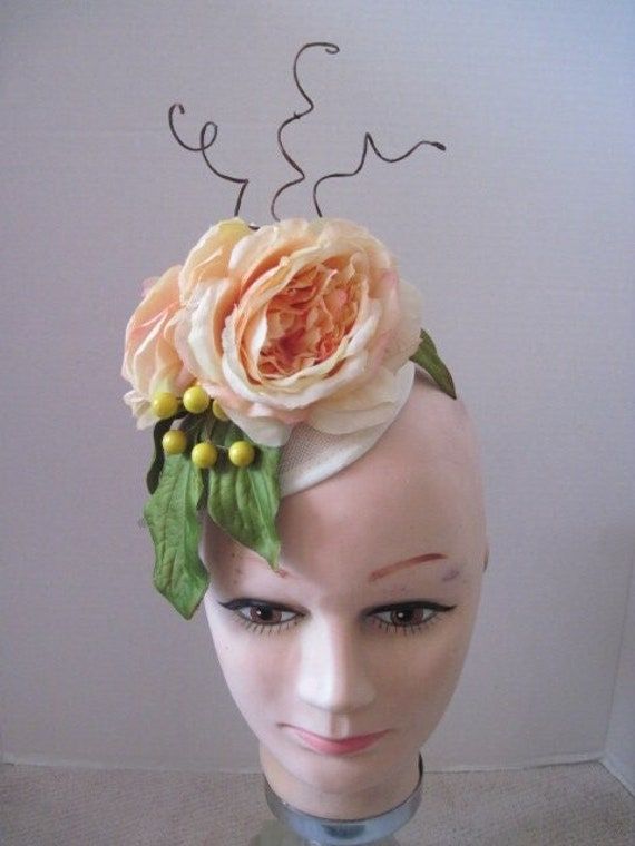 *  A touch of flowers for the spring and summer seasons will brighten anyone's day.  This fascinator features two large pale yellow blooming roses and accented with yellow berries and curly sticks. *  It is on a round Sinamay hat form and is held in place with a sturdy clip which allows positioning as desired. *  It is well balanced and comfortable to wear over extended periods of times.    *  Great for the Annual Easter Egg Hunt,  Easter Parade and Festival, Easter dinner, Church Social or Even Branch Headpiece, Hat Form, Sinamay Hat, Spring Garden Party, Ladies Luncheon, Feather Headpiece, Sinamay Hats, Hat Base, Easter Parade