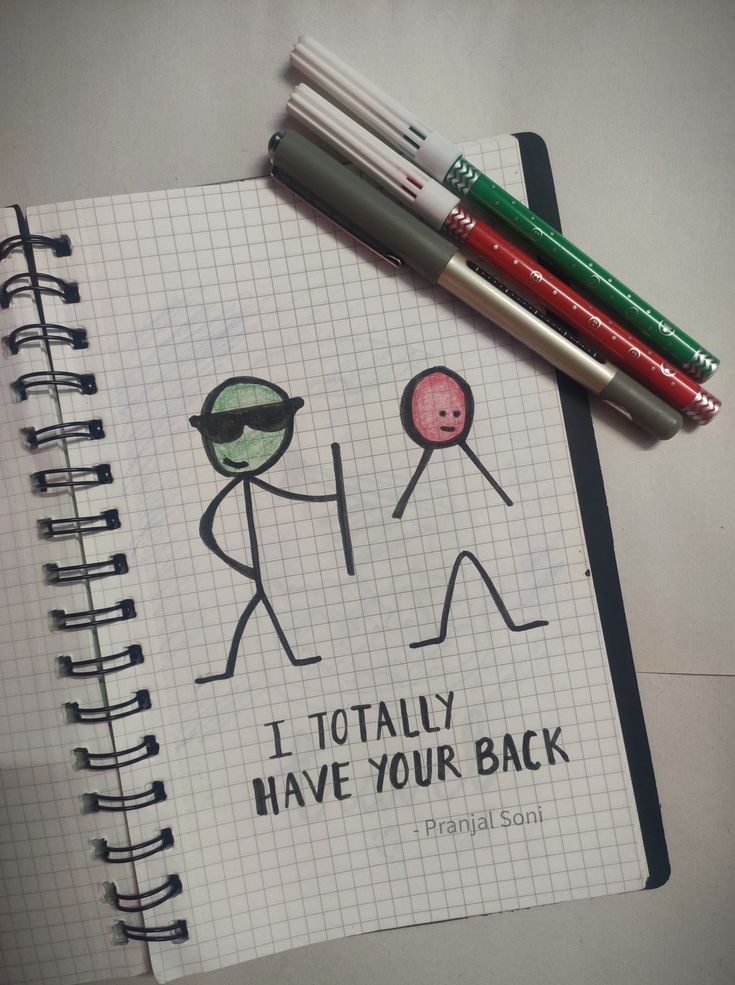 two pens are sitting on top of a notebook with an image of people holding hands and the words i totally have your back