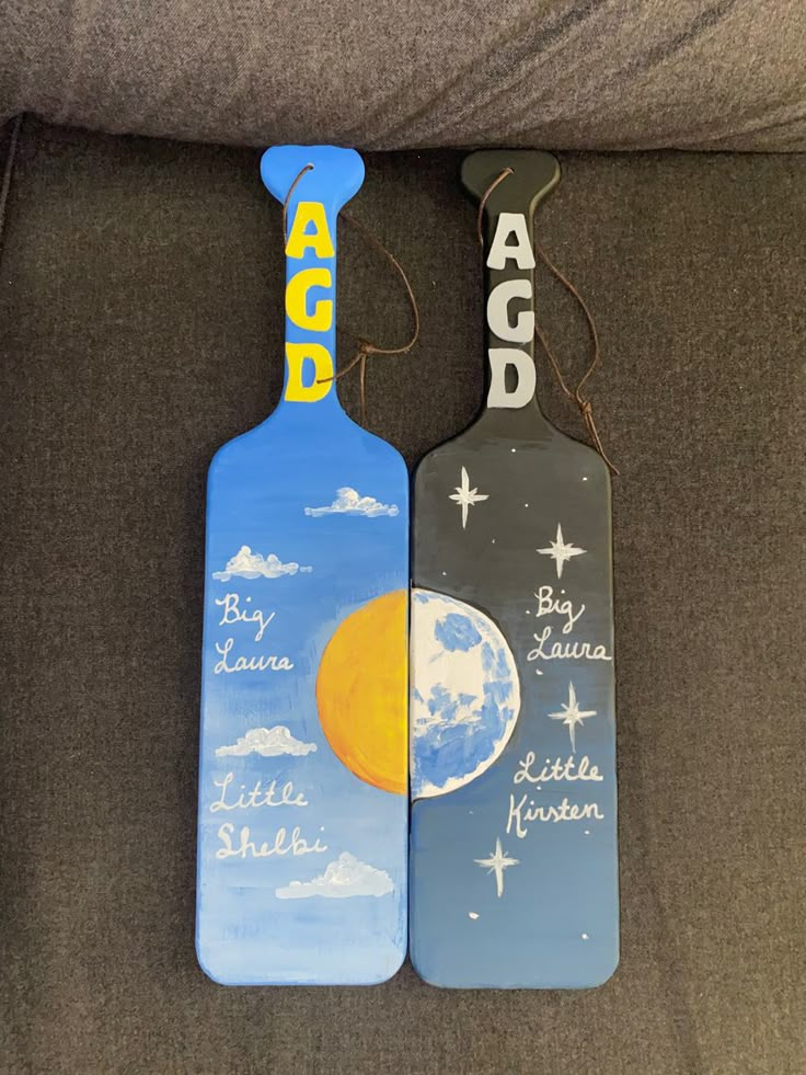 two paddles with the names of different countries on them sitting on a couch next to each other