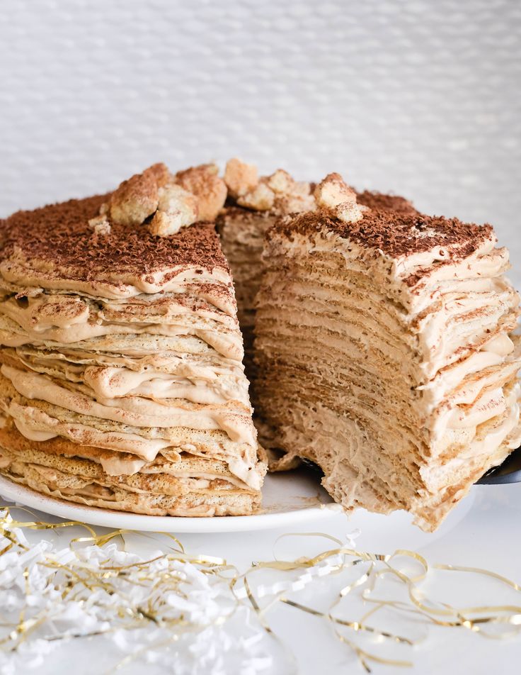 a cake that has been cut in half on a white plate with gold decorations around it