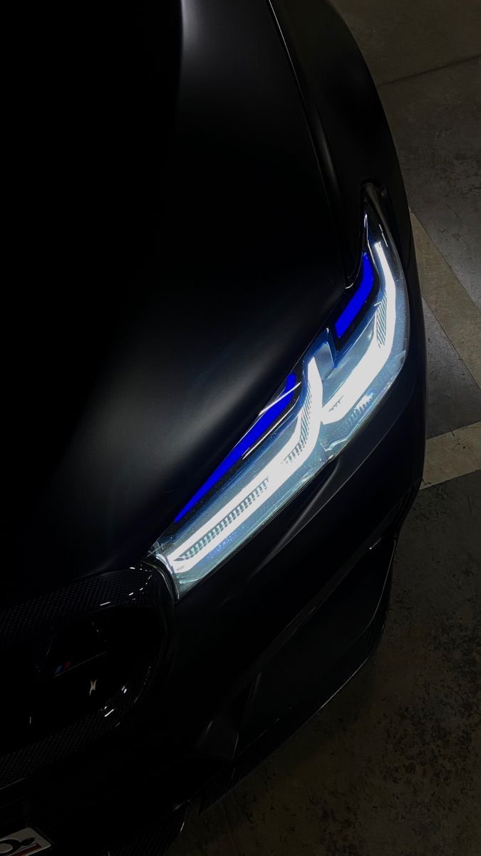 the front end of a black car with blue lights