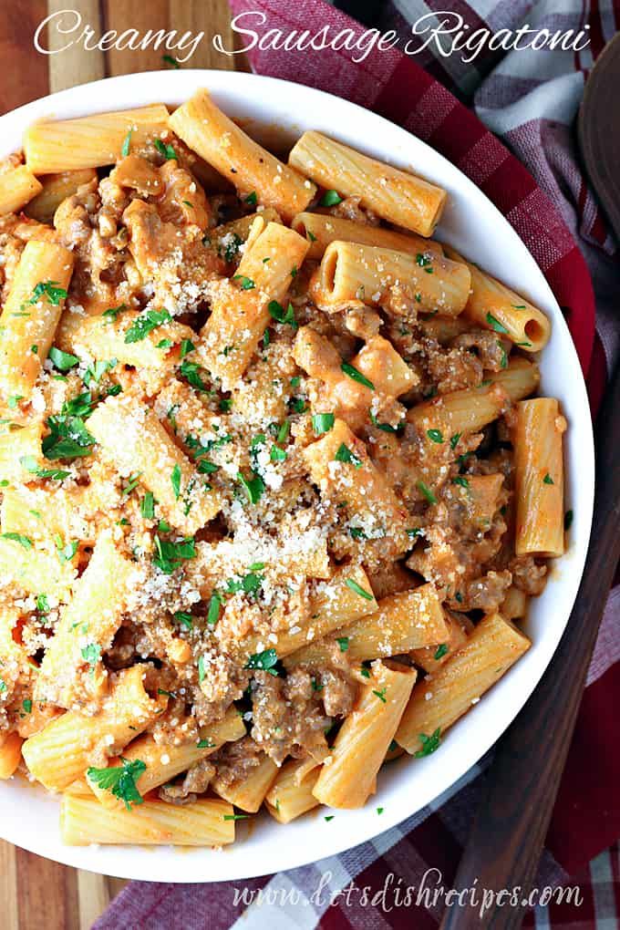 pasta with meat and parmesan cheese in a white bowl on a wooden table