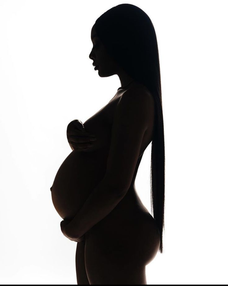 the silhouette of a pregnant woman with long hair