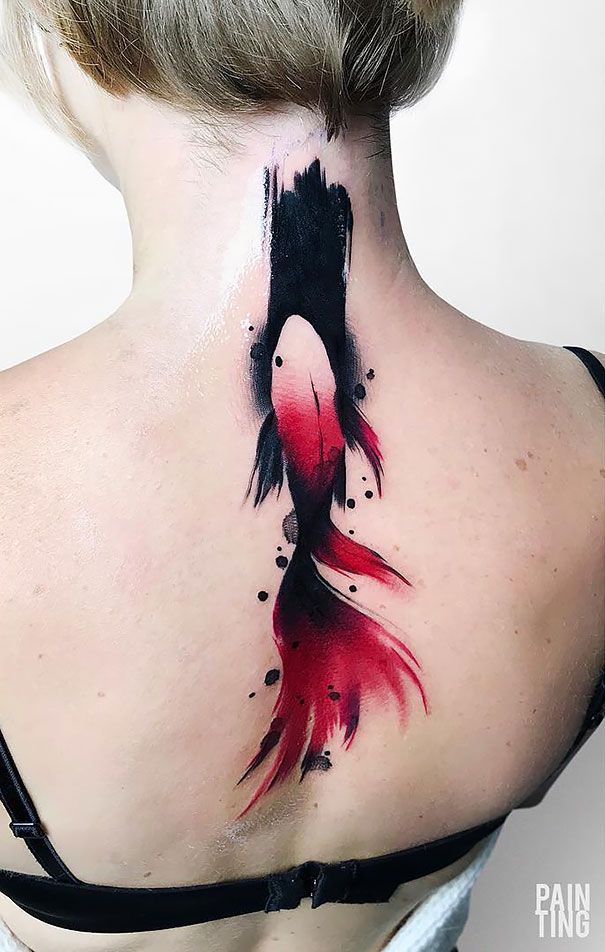 the back of a woman's neck is covered with watercolors and has a fish tattoo on it