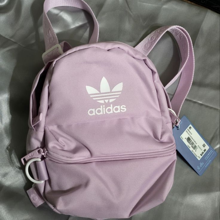 New With Tags! Color : Orchid Fusion Purple Features Two Compartments. The Large Main Compartment Has A Zipper/Netted Pocket. The Smaller Compartment Also Has A Little Pocket And A Key Holder. Adjustable Straps. 8"L X 6" W Pink Adidas Backpack For Daily Use, Adidas Pink Backpack For Daily Use, Trendy Adidas Backpack For Everyday Use, Adidas Backpack For Students, Trendy Adidas Backpack For Back To School, Trendy Adidas Backpack, Trendy Adidas School Backpack, Trendy Adidas Standard Backpack, Adidas School Bag With Zipper Closure