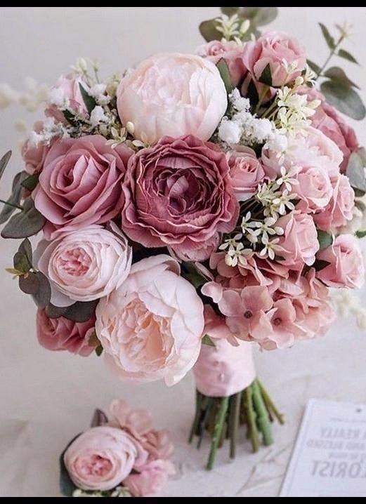 a bouquet of pink flowers sitting on top of a table