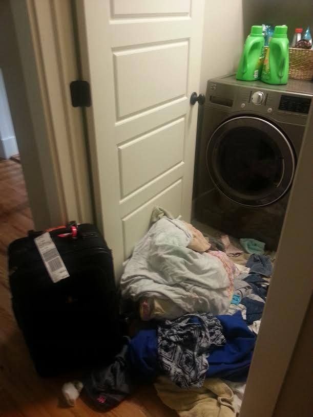 the laundry is piled up next to the washer and dryer in the room