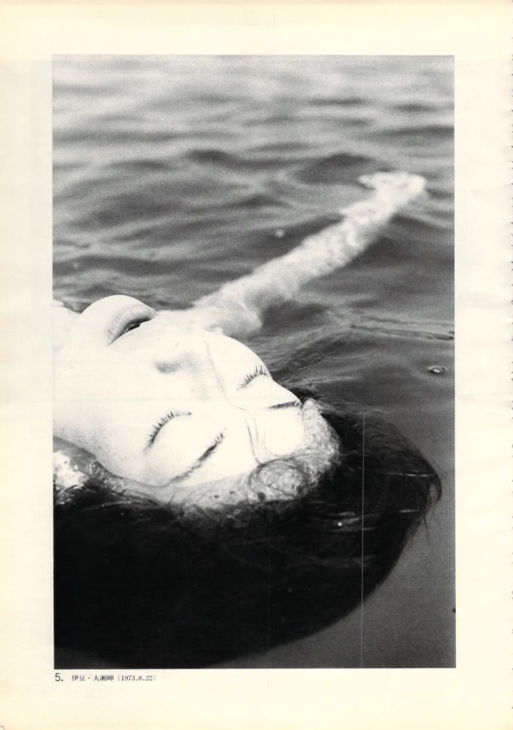 an old photo of a woman floating in the water