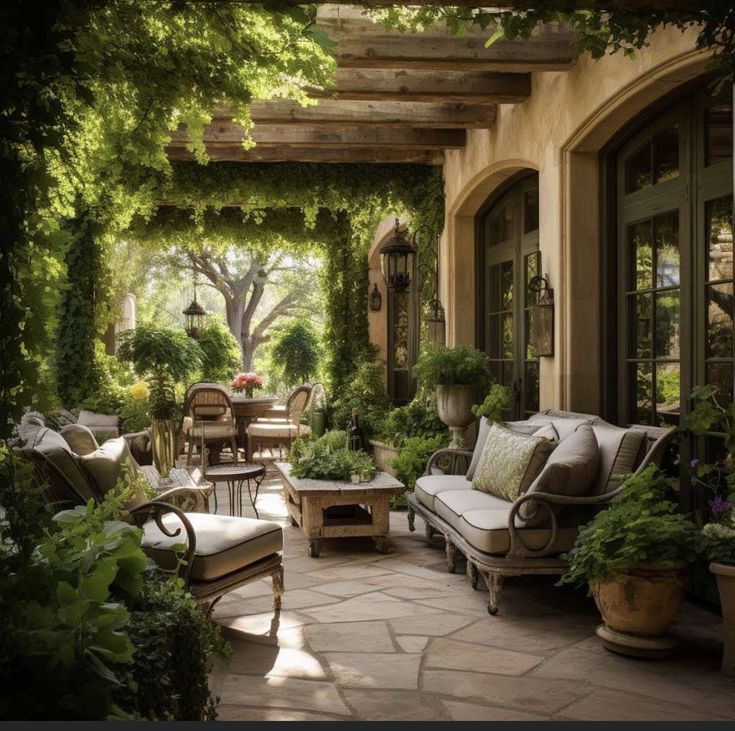 an outdoor living area with couches, tables and potted plants