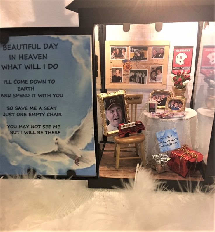 there is a display with pictures and other items in the room, including a sign that says beautiful day in heaven what will i do