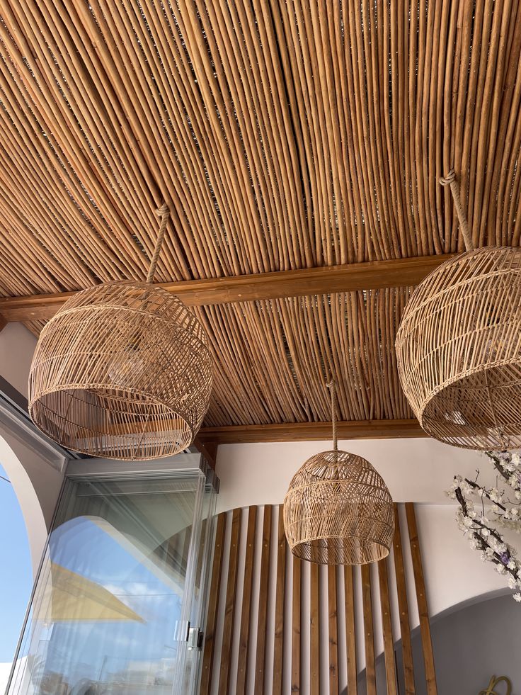 three wicker lamps hanging from the ceiling