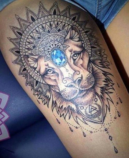 a woman's thigh with a tattoo on it and a wolf head in the center