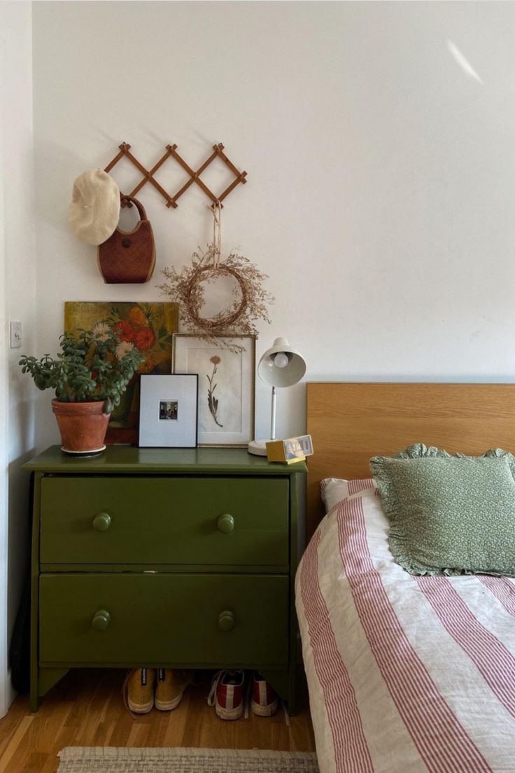 a bed room with a neatly made bed and green dresser