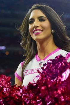 a cheerleader is smiling and holding her pom - poms