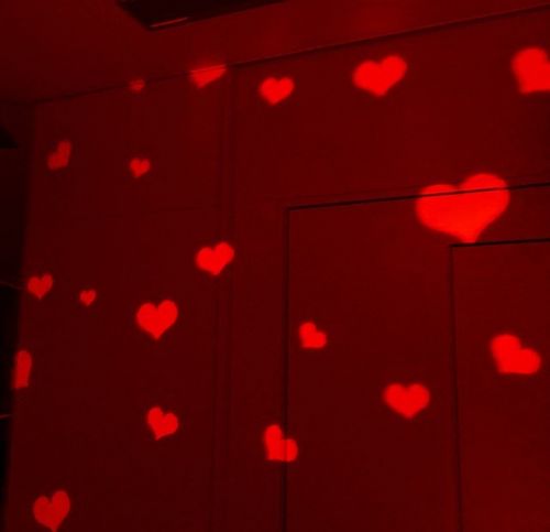 red hearts are projected on the wall in this room