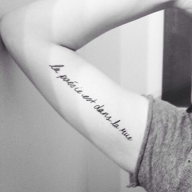 a woman with a tattoo on her arm that says,'a friend is always right behind you '