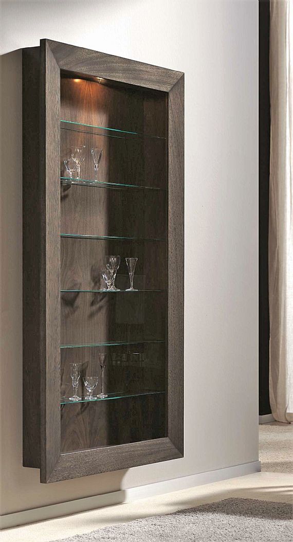 a wooden display case with glass shelves on the wall next to a carpeted floor