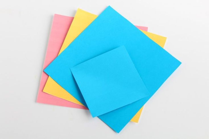 four different colored papers stacked on top of each other with one folded in the middle