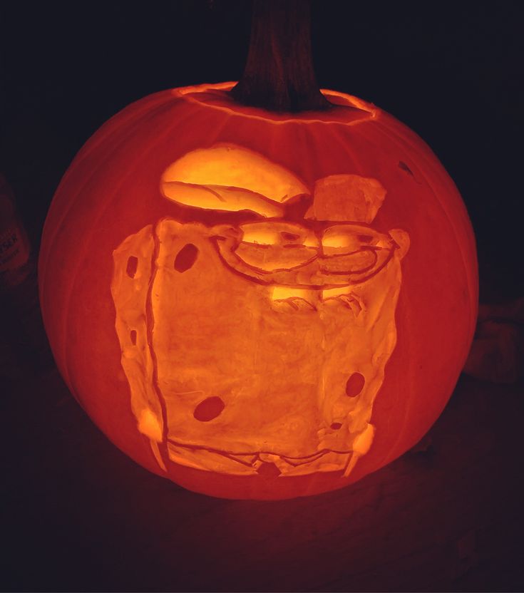 a carved pumpkin with an image of spongebob on it's face in the dark