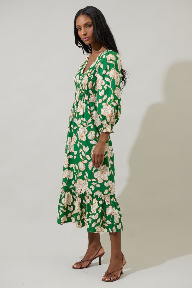 A season favorite list has to include the Lucena Floral Lemy Poplin Midi Dress. It features long sleeves, smocked bodice, and a v-neckline. The bottom has a ruffle hem tier. Wear it with matching ivory heels to create a full look. - Smocked- Deep V-neck- Floral- Lined- Color: Green MultiSize + Fit - Model is 5'10" and wearing size XS- Measurements taken from size S - Chest: 15 1/4"- Length: 49 3/4" Fabric Self: 100% Cotton, Lining: 97% Polyester 3% Spandex Style Number STD14589P Green Ruched Midi Dress For Fall, Spring V-neck Smocked Dress For Daywear, Green Long Sleeve Dress With Smocked Cuffs, Casual Green Dress With Elastic Sleeves, Green Smocked Dress With Gathered Sleeves, Spring V-neck Dress With Smocked Cuffs, Green Dresses With Elastic Sleeves For Brunch, Green Midi Dress With Elastic Sleeves, Green V-neck Midi Dress With Smocked Bodice