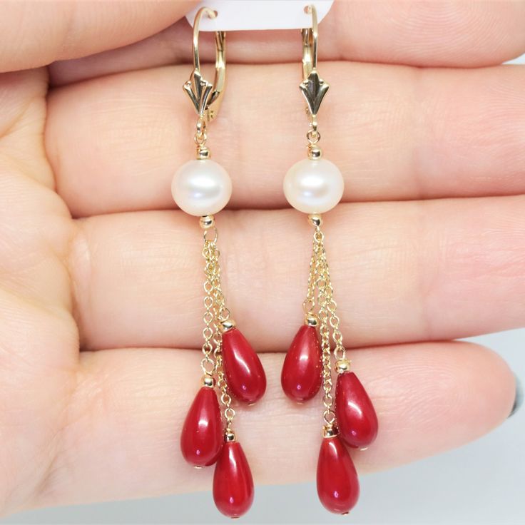 These stunning earrings are made with 14k solid yellow gold, natural freshwater round Pearl and red Coral teardrop stones.  Metal: 14k solid yellow gold Stone: Natural freshwater Pearl (7mm approx.), red Coral (9X5mm approx.)  Chain type: Cable Closure: Lever backs Fleur-De-Lis  Golden balls: 10pc. -  2mm approx.  Total length: 2 1/2 inches approx. Total weight: 4 g. approx. IMPORTANT NOTE: These pictures are maximum zoomed in, so the actual size of the jewelry is noted in the description. We st Formal Red Hypoallergenic Jewelry, Red Hypoallergenic Jewelry For Formal Occasions, Hypoallergenic Red Jewelry For Formal Occasions, Fine Jewelry Red Dangle Earrings, Hypoallergenic 14k Gold Red Jewelry, Classic Red Pear-shaped Jewelry, Red Pearl Drop Round Earrings, Red Round Pearl Drop Earrings, Formal Red Pearl Drop Jewelry