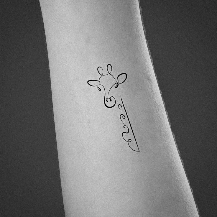 a small giraffe tattoo on the ankle that is black and white with dots