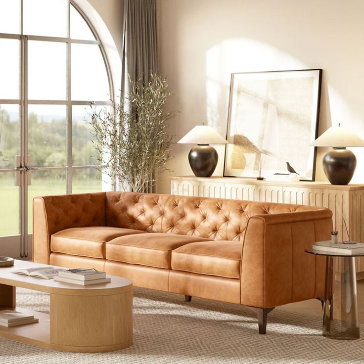 a living room filled with furniture and a large window overlooking a field in the distance