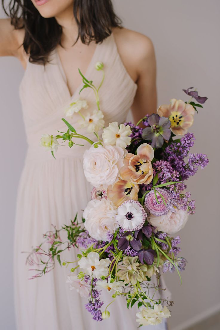 a woman holding a bouquet of flowers in her hands