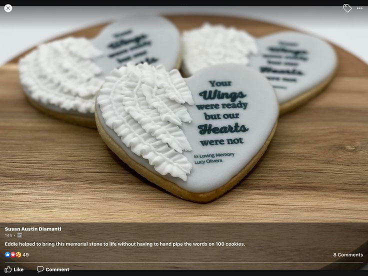 three heart shaped cookies with white icing on a wooden board that says, you wings were ready but our hearts were not