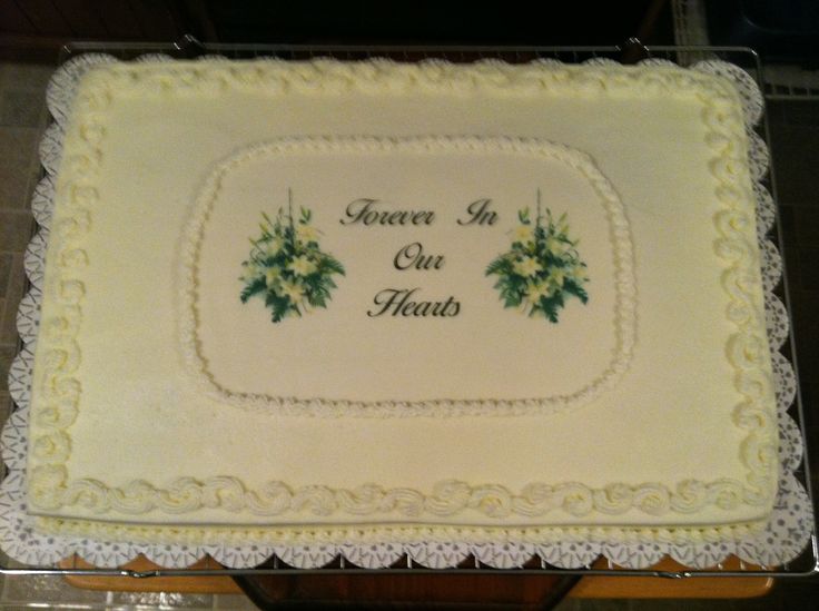 a cake with white frosting and green flowers on the side that says peace in our hearts