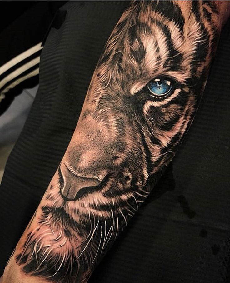 a tiger tattoo with blue eyes on the arm