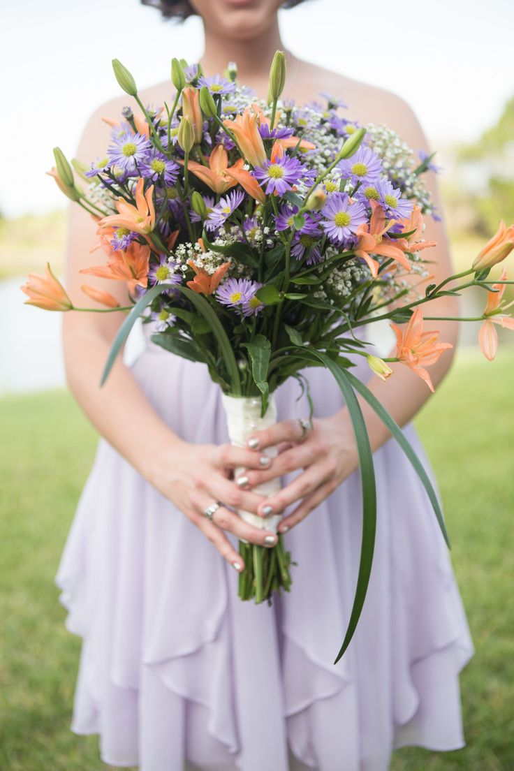 a woman holding a bouquet of flowers in her hands