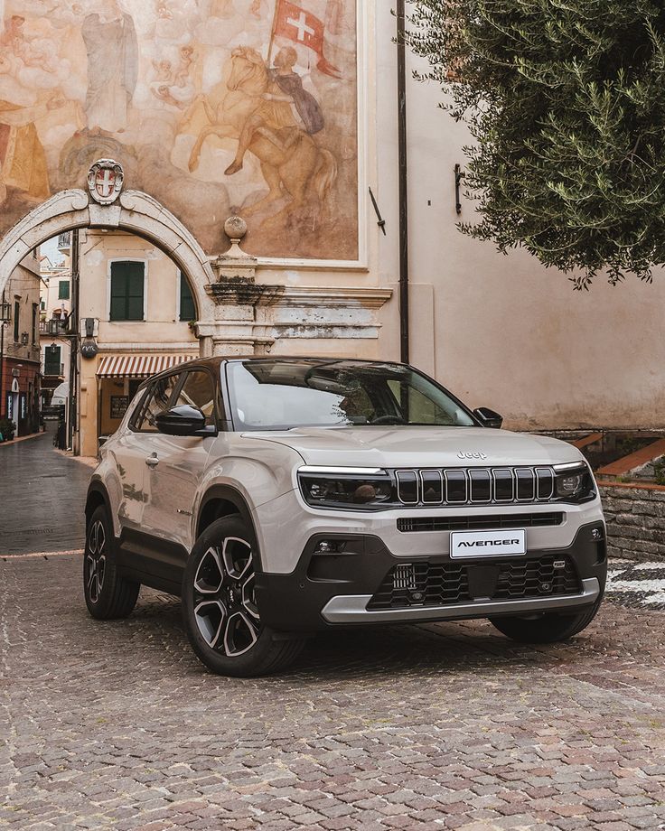 a silver jeep parked in front of a building