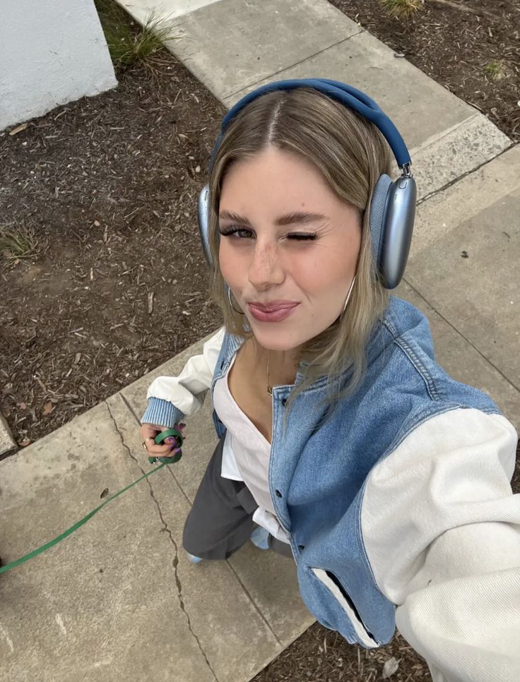 a girl with headphones on walking her dog