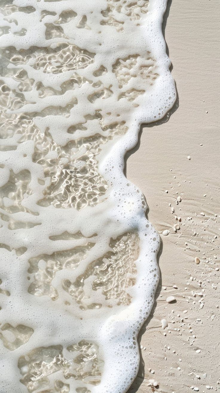 the water is foamy on the sand at the beach