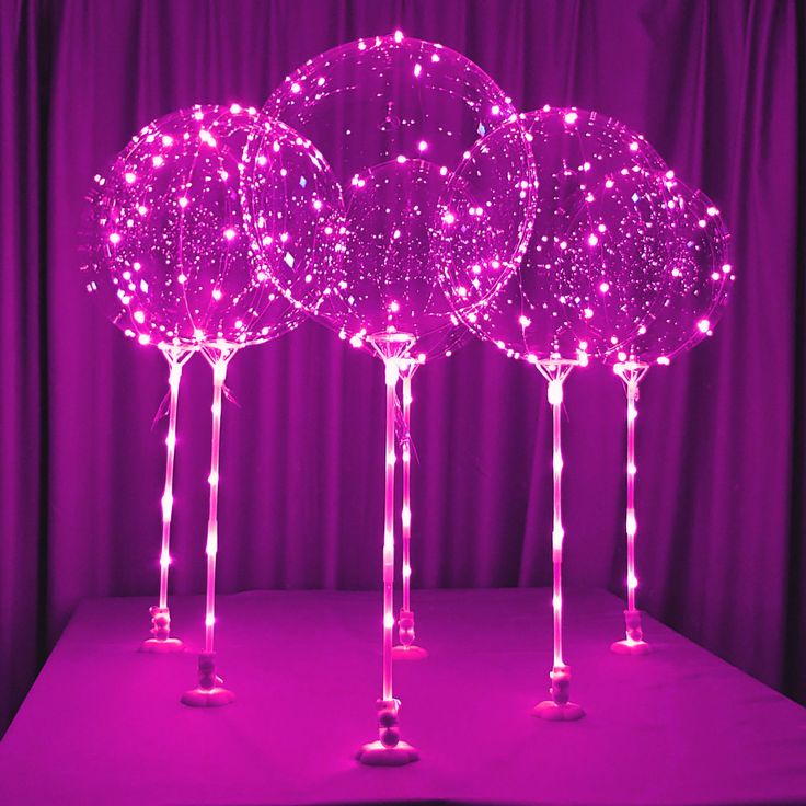 three pink lighted trees on top of a table