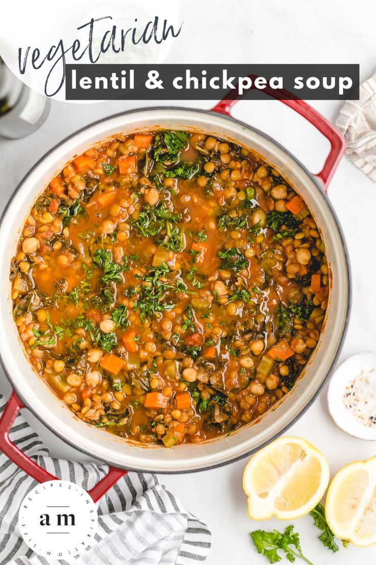 a pot filled with beans and greens on top of a white table next to sliced lemons