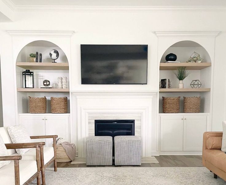 a living room with two couches and a television on top of a fireplace mantel