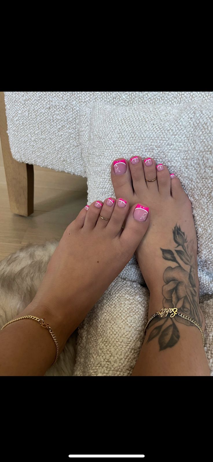 a woman with pink nail polish on her feet and foot next to a white towel