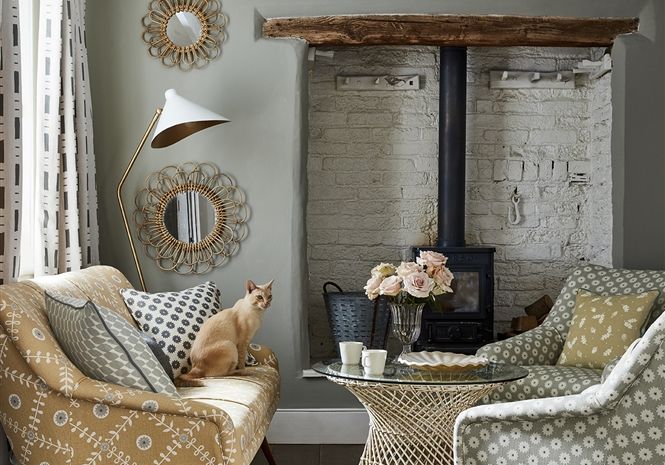 a living room with two chairs and a cat sitting on the chair next to it