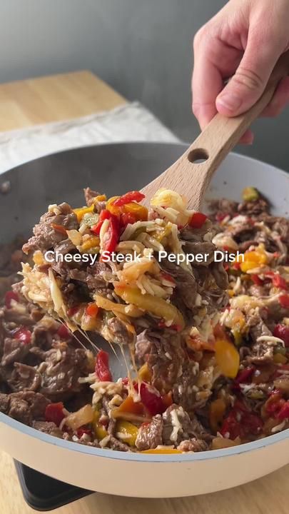 a person is stirring some food in a pan with a wooden spatula to stir it