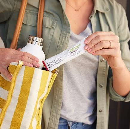 a woman is holding a bag with a tube in it and an empty bottle inside