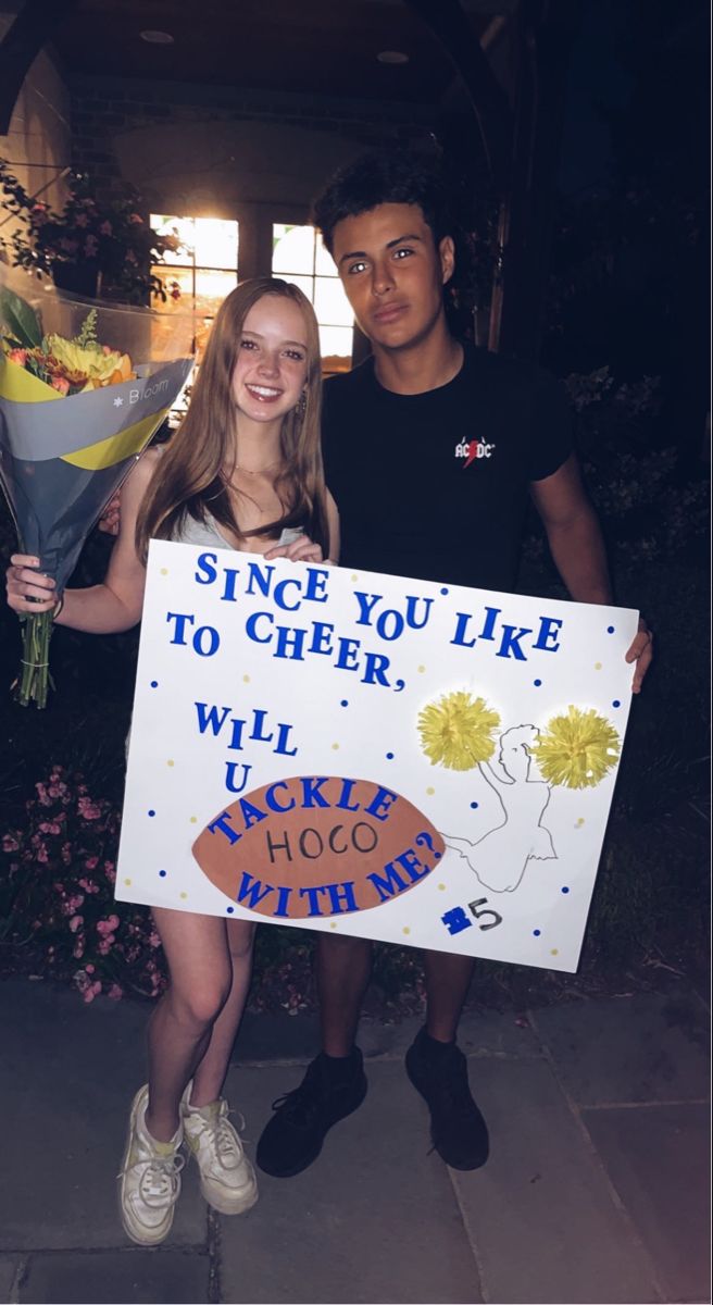 two people standing next to each other holding flowers and a sign that says, since you like to cheer