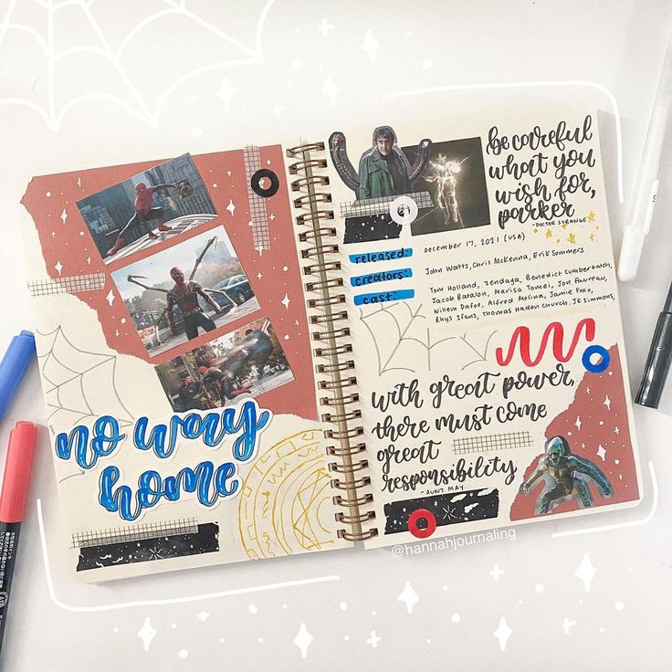 an open notebook with pictures and writing on the pages, next to markers and pens