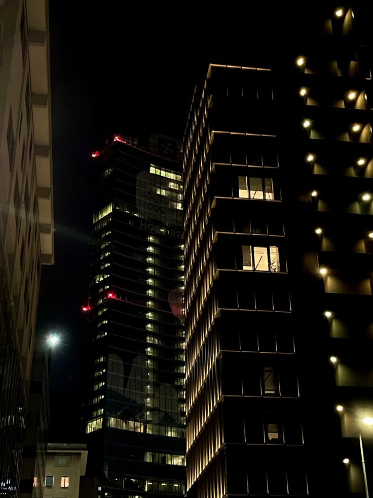 some very tall buildings in the city at night